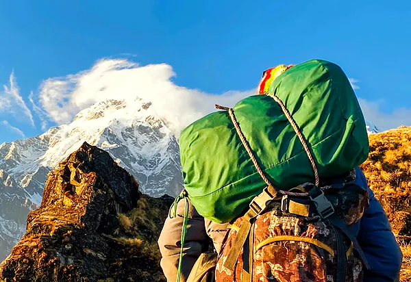 A hiker with a big pack looking out at Himalayan peaks