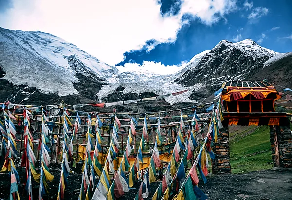 Tibetan prayer flags strung beneath snow-capped peaks